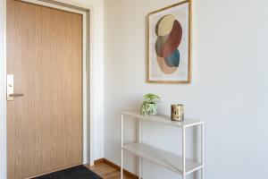 ein Flur mit einer Tür, einem Regal und einem Bild in der Unterkunft Forenom Aparthotel Luleå Västra Stranden in Luleå