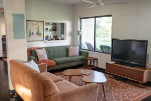 a living room with a couch and a flat screen tv at Sunset Oaks Retreat Events, Farm Animals & Views in Saint Jo