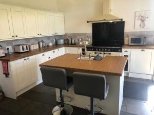 a kitchen with white cabinets and a wooden counter top at St Annes House Double Room 6 in Plymouth