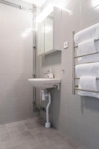 ein Badezimmer mit Waschbecken, Spiegel und Handtüchern in der Unterkunft Forenom Aparthotel Luleå Västra Stranden in Luleå + 13 Fotos