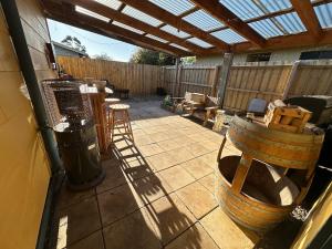 a patio with a table and chairs and a barrel at South Dudley Beach House - Pet friendly in Dudley South