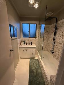 a bathroom with a tub and a sink and a shower at South Dudley Beach House - Pet friendly in Dudley South