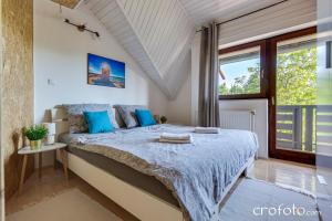 una camera da letto con un letto grande con cuscini blu di Villa Mavi a Drežnik Grad Altre 13 foto