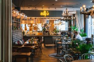a restaurant with tables and chairs and a bar at Radisson Blu Metropol Helsingborg in Helsingborg