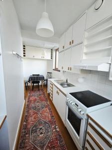 a kitchen with white cabinets and a rug on the floor at Aalto residence in Rovaniemi