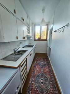a kitchen with white cabinets and a rug on the floor at Aalto residence in Rovaniemi +11 photos
