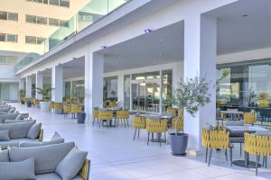 an empty lobby with tables and chairs in a building at King Evelthon Beach Hotel & Resort in Paphos
