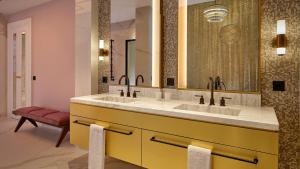 a bathroom with two sinks and a large mirror at Hotel Taschenbergpalais Kempinski in Dresden +85 photos