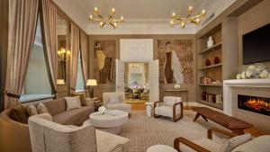 a living room with a couch and a fireplace at Hotel Taschenbergpalais Kempinski in Dresden