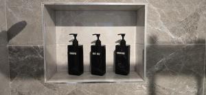 three black electric toothbrushes in a holder on a wall at Lux Apartman Stojanović in Belgrade