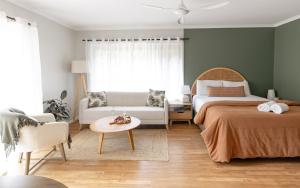 尼尔森湾Saltbush Retreat的一间卧室，有两张床、一张沙发和一张桌子