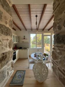 una cucina e una sala da pranzo con parete in pietra di Garden Residence a Ermoupoli