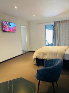 伯诺尼Linies guest house的一间卧室，墙上有一张床和一台电视 更多33张照片