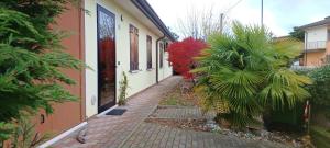 ein gemauerter Gehweg neben einem Haus mit einer Palme in der Unterkunft Villa Polesine in Porto Tolle