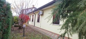 ein weißes Haus mit einem Bürgersteig neben einem Gebäude in der Unterkunft Villa Polesine in Porto Tolle