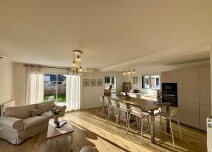 滨海莫厄朗Les Cocons d'Agathe La Maison M 10 min from beaches的配有桌子和沙发的厨房和客厅