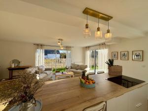 滨海莫厄朗Les Cocons d'Agathe La Maison M 10 min from beaches的厨房以及带大型木制台面的客厅。