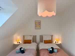 滨海莫厄朗Les Cocons d'Agathe La Maison M 10 min from beaches的卧室内的两张床和泰迪熊