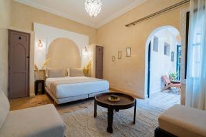 een hotelkamer met twee bedden en een tafel bij Riad Beldi in Marrakesh +121 foto's