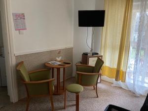 Una habitación con una mesa y sillas y un televisor. en Amfora Panzió, en Gyula