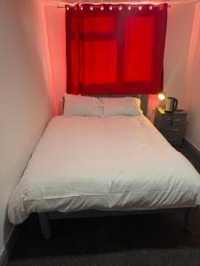 バーミンガムにあるPrime Hotelのベッドルーム1室(赤い天蓋付きのベッド1台付)