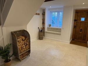a hallway with a staircase with a basket of fire wood at Luxury Lechlade cottage - Character and charm in Lechlade +27 photos