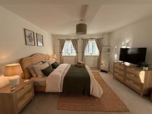 a bedroom with a bed and a flat screen tv at Luxury Lechlade cottage - Character and charm in Lechlade