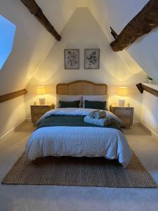 a bedroom with a large bed with two night stands at Luxury Lechlade cottage - Character and charm in Lechlade