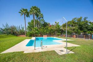 una piscina en un patio con palmeras en Axarquía beach junto al mar, en Vélez-Málaga