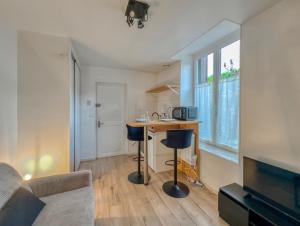 a living room with a kitchen with a table in it at Le Clemenceau 2 in Margny-lès-Compiègne