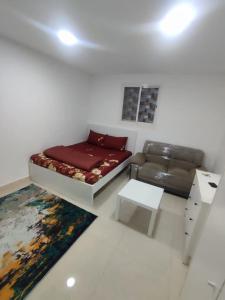 a living room with a bed and a couch at oshsus jahsvsb in Al Ain