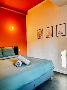 布里尼奥勒Juni - Climatisé & Balconnet的卧室里有一张床，墙壁是橙色的