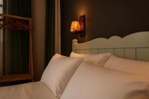 艾瓦勒克Defne Pansiyon Ayvalık的卧室里有一张带白色枕头的床