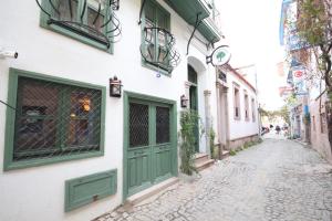 艾瓦勒克Defne Pansiyon Ayvalık的老城区的一条街道，两旁是绿色的门