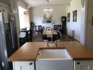 St Annes House Double Room 7 في بلايموث: مطبخ مع حوض وغرفة طعام مع طاولة