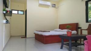 a small bedroom with a bed and a table at Patil villa in Nagaon