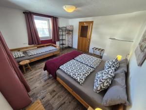 涅德劳Ferienwohnung Neuheim的一间卧室设有两张床、一张沙发和一个窗口