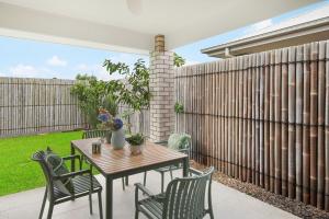 MarsdenLogan Reserv 5BR Near Large Business District Fully Air-Conditioned With Parking的带围栏的露台上的桌子和椅子