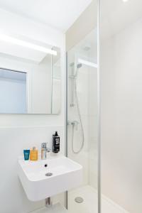 um banheiro branco com pia e chuveiro em ibis budget Perpignan Centre Rénové en 2025 - Hôtel Economique au Centre ville de Perpignan em Perpignan mais 160 fotografias