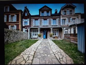 a large brick house with a stone path in front of it at Soleil du Matin in Étretat