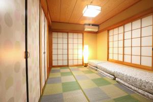 a room with a row of benches in a japanese room at 庭音日和 2つの半露天壺湯でくつろぐ宿 大家族向け広々一棟貸し 駐車場2台 浴室2箇所 in Omihachiman