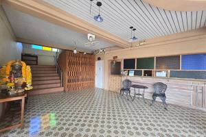 um quarto com duas cadeiras, uma mesa e escadas em SK Hotel Phitsanulok em Ban Nong Chaeng