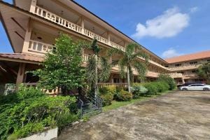 um prédio com um carro estacionado na frente em SK Hotel Phitsanulok em Ban Nong Chaeng