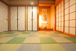 a room with a tiled floor and glass doors at 庭音日和 2つの半露天壺湯でくつろぐ宿 大家族向け広々一棟貸し 駐車場2台 浴室2箇所 in Omihachiman
