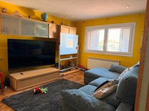 a living room with a couch and a large flat screen tv at Una casa ideal para familias o grupos de amigos in Caldes de Malavella