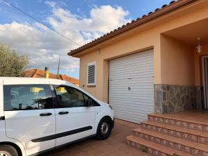 a white van parked in front of a garage at Una casa ideal para familias o grupos de amigos in Caldes de Malavella