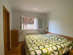 a bedroom with a bed and a window at Una casa ideal para familias o grupos de amigos in Caldes de Malavella