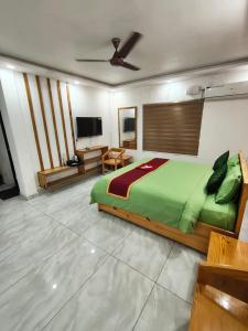 1 dormitorio con 1 cama verde y TV en Moody Moon Vagamon, en Vagamon