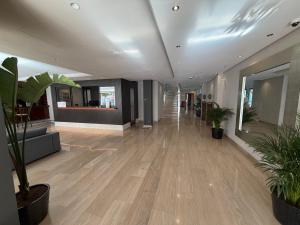 an office lobby with wooden floors and potted plants at Leflet Valme in Dos Hermanas