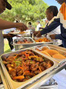 a group of people standing around a buffet of food at Rio Eco Gardens Hotel in Nairobi